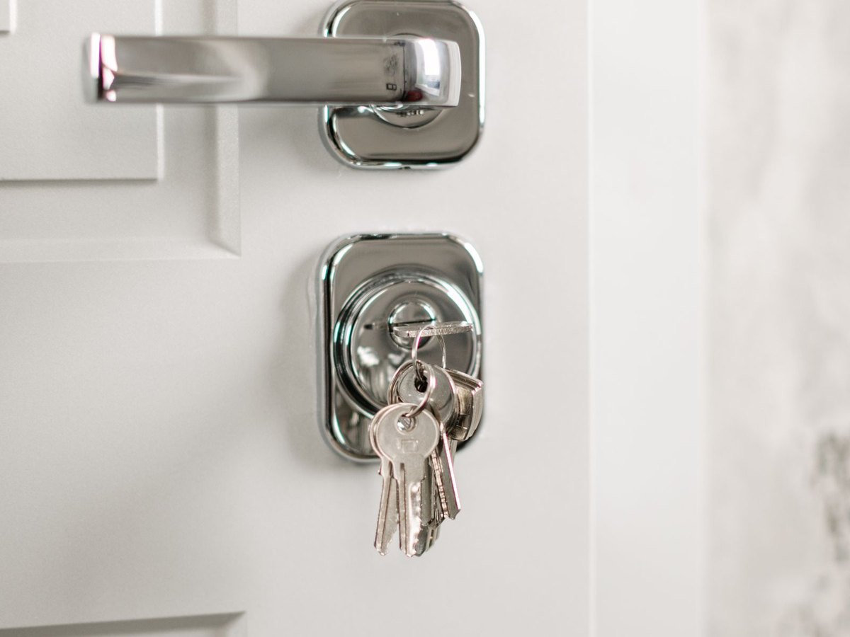 A set of keys left hanging in a door lock cylinder